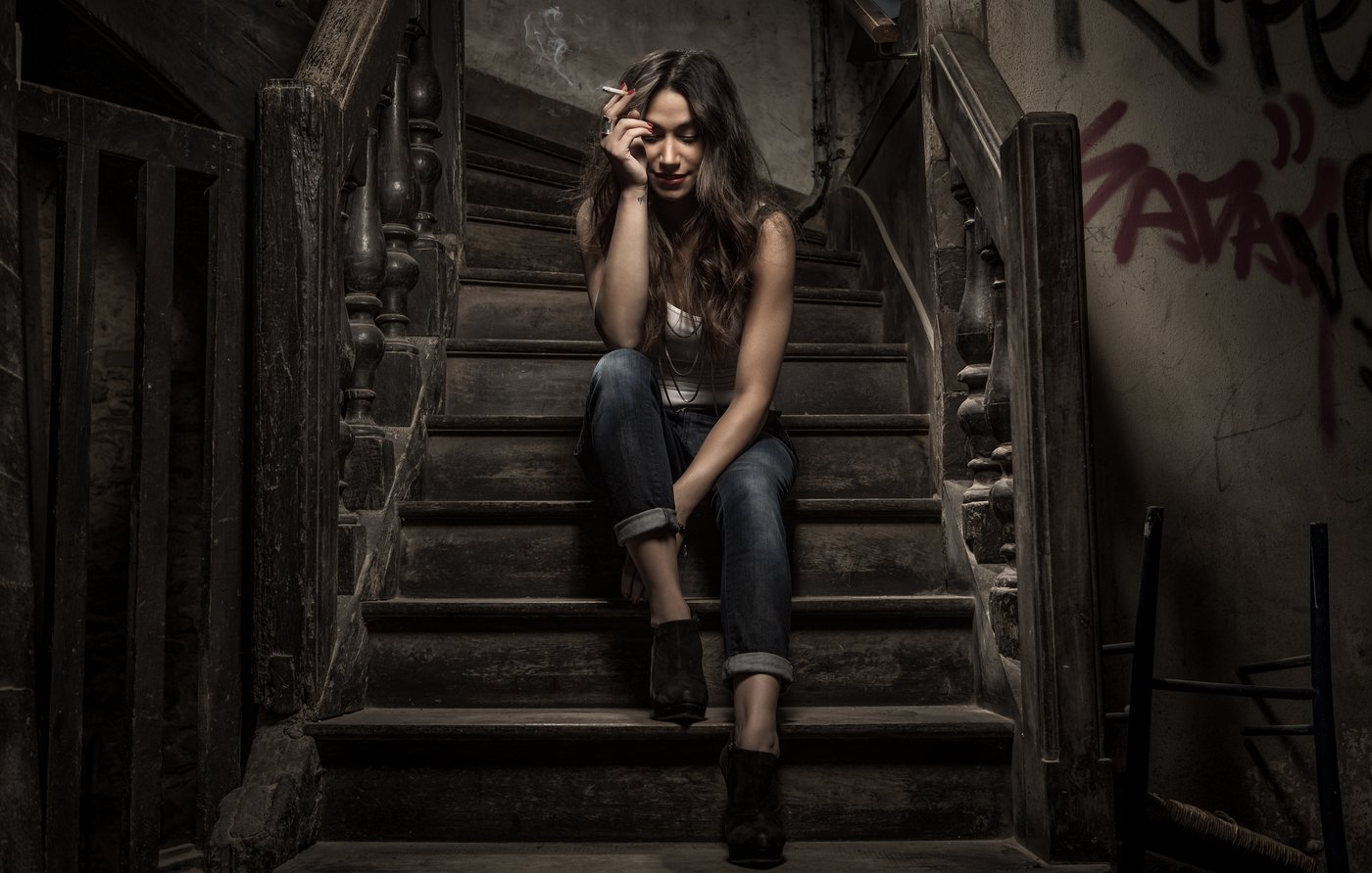 Femme assise dans un escalier ancien